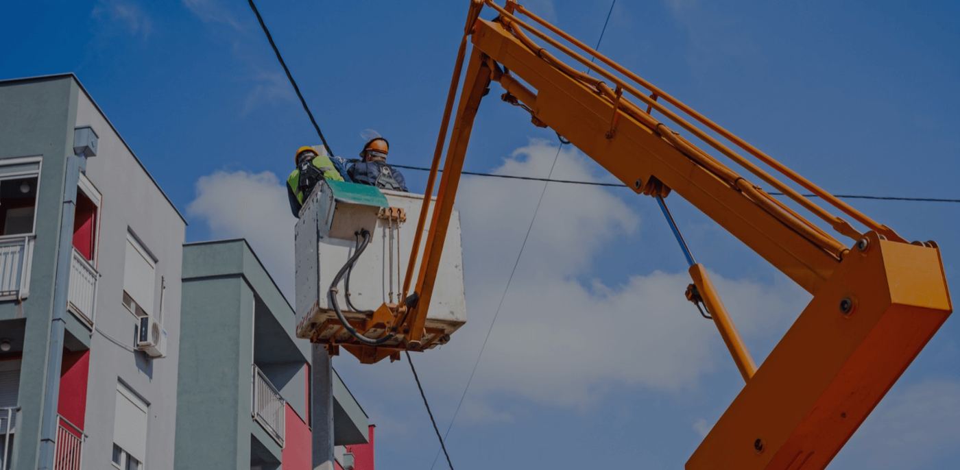 OEC crew performing electrical service at a commercial building from a boom lift
